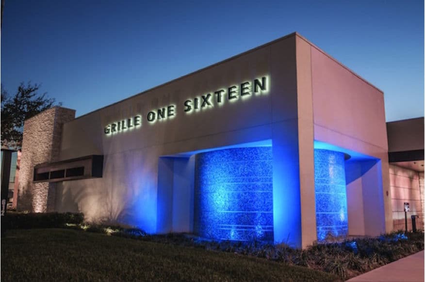 Modern restaurant exterior of Grille One Sixteen illuminated at dusk.